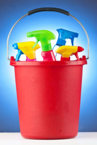 A red bucket filled with assorted cleaning supplies.